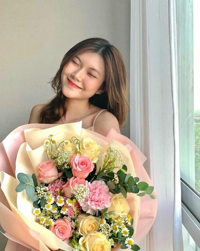 ảnh gái xinh cầm hoa ngoài trời
